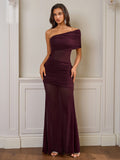 Model posing in a burgundy one-shoulder ruched gown