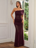 Close-up of a woman wearing a burgundy one-shoulder ruched gown