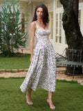 Woman twirling in a floral print midi dress with a sweetheart neckline and high slit