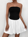 Model posing in a black and white strapless dress