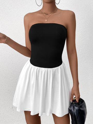 Woman wearing a black strapless bodice with a white gathered skirt, front view