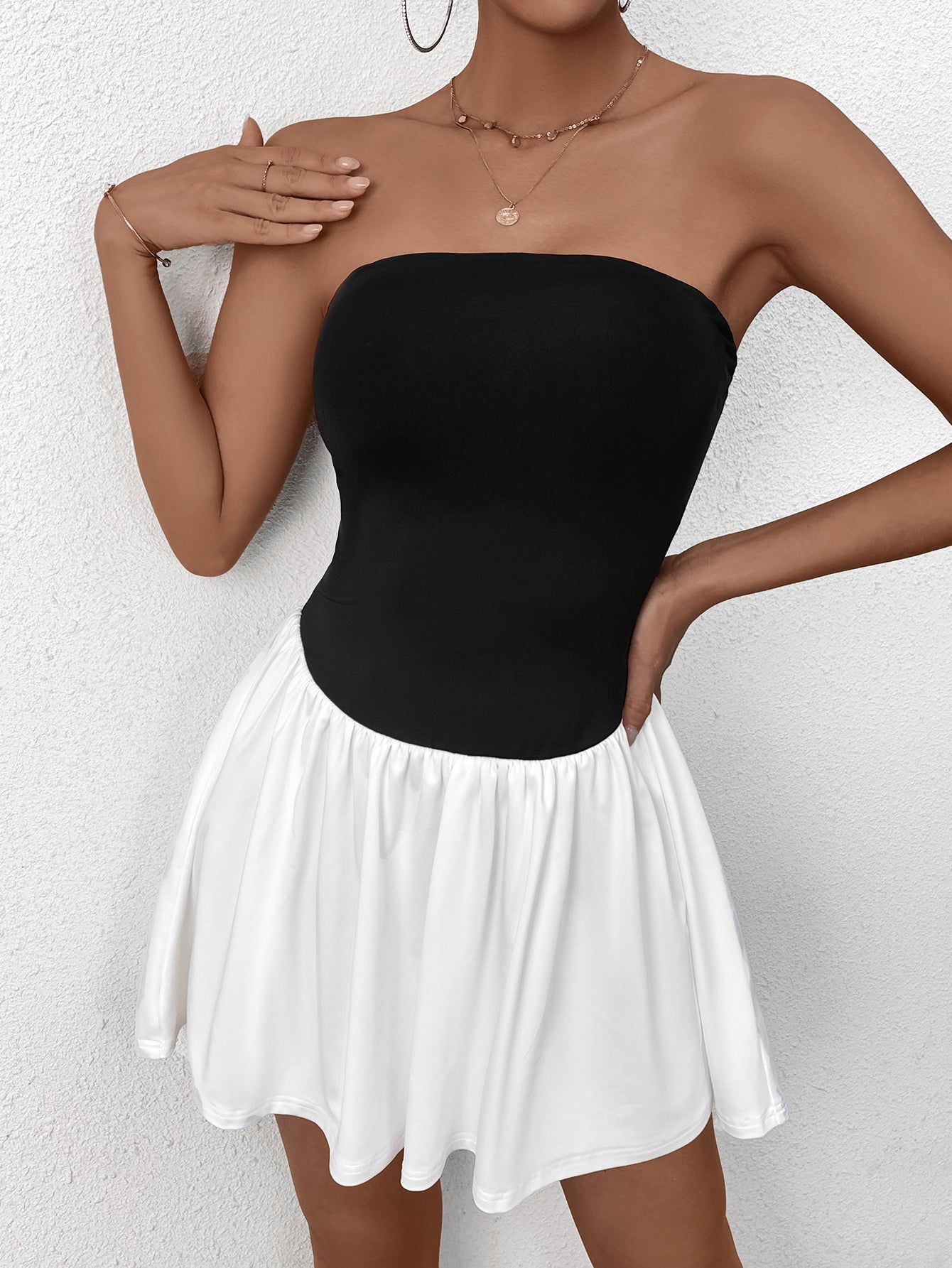 Close-up of a woman wearing a black strapless bodice with a white gathered skirt