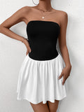 Woman wearing a black strapless bodice with a white gathered skirt, side view