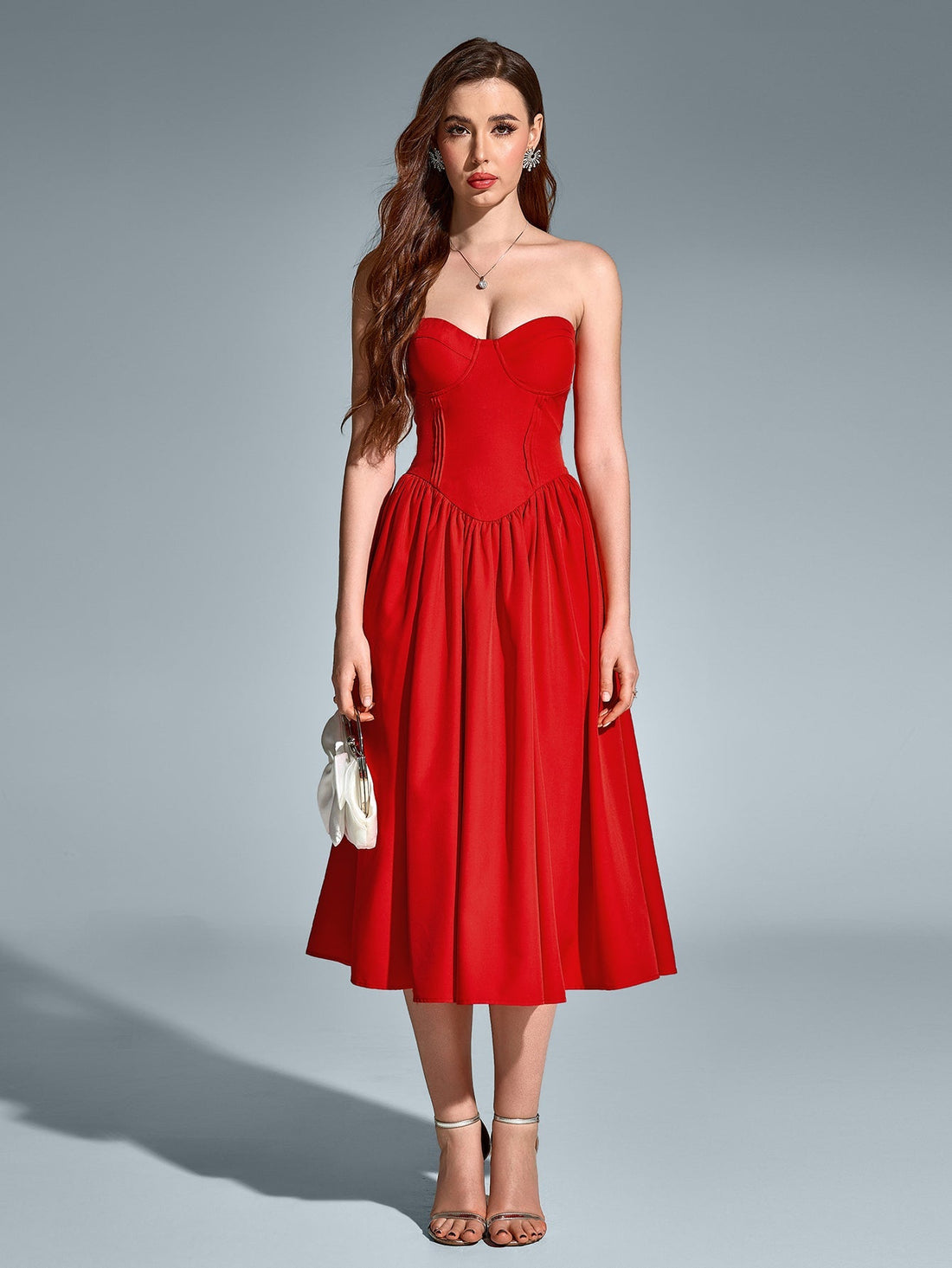 Woman in a red strapless satin midi dress with a sweetheart neckline and fitted waist.