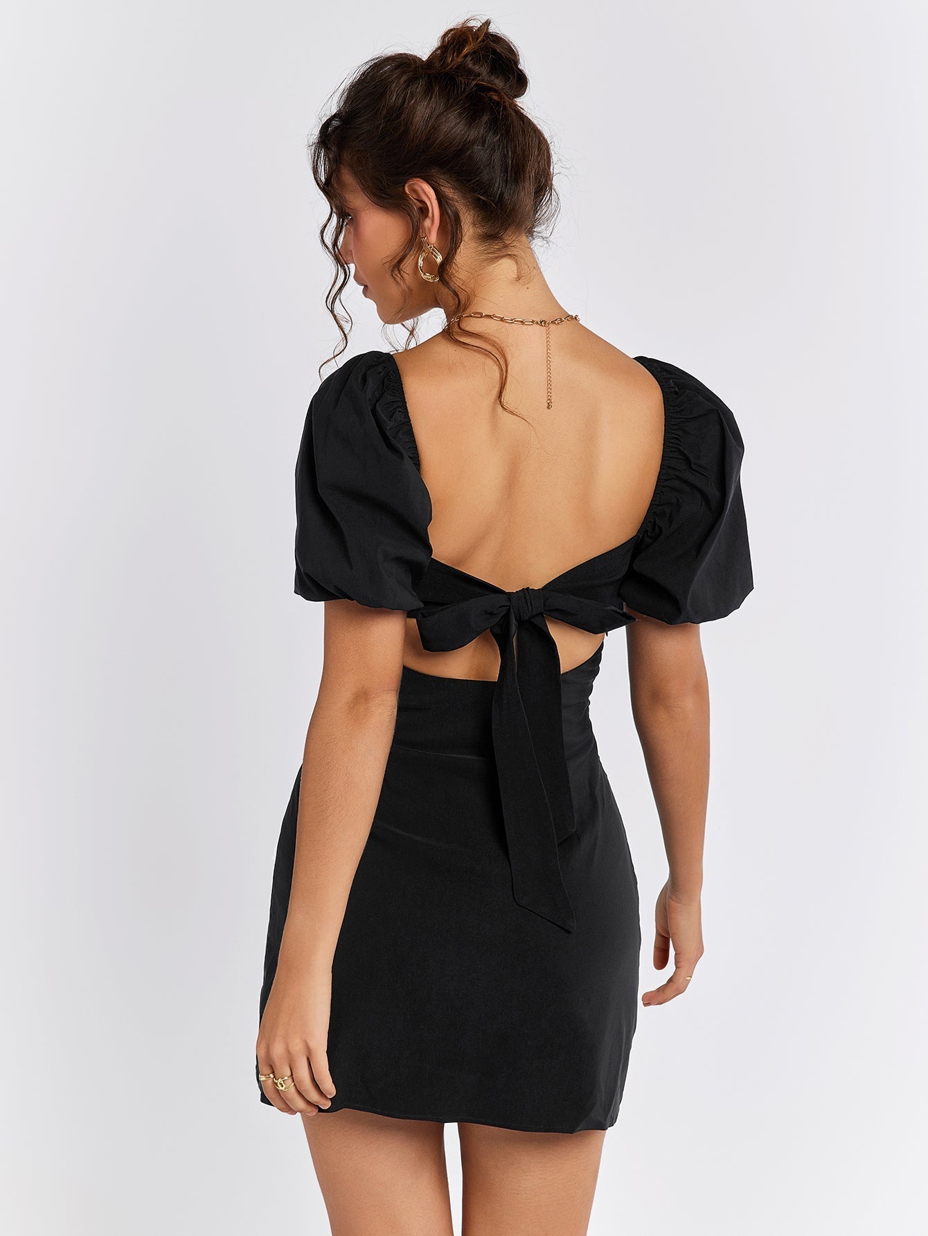 Back view of a black puff sleeve dress with a tie closure