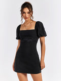 Front close-up of a black puff sleeve dress with square neckline and lace detail