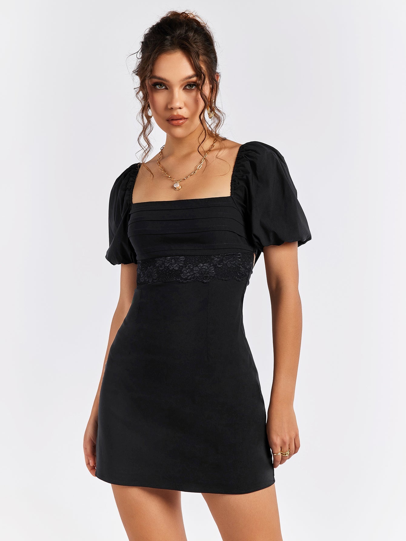 Front close-up of a black puff sleeve dress with square neckline and lace detail