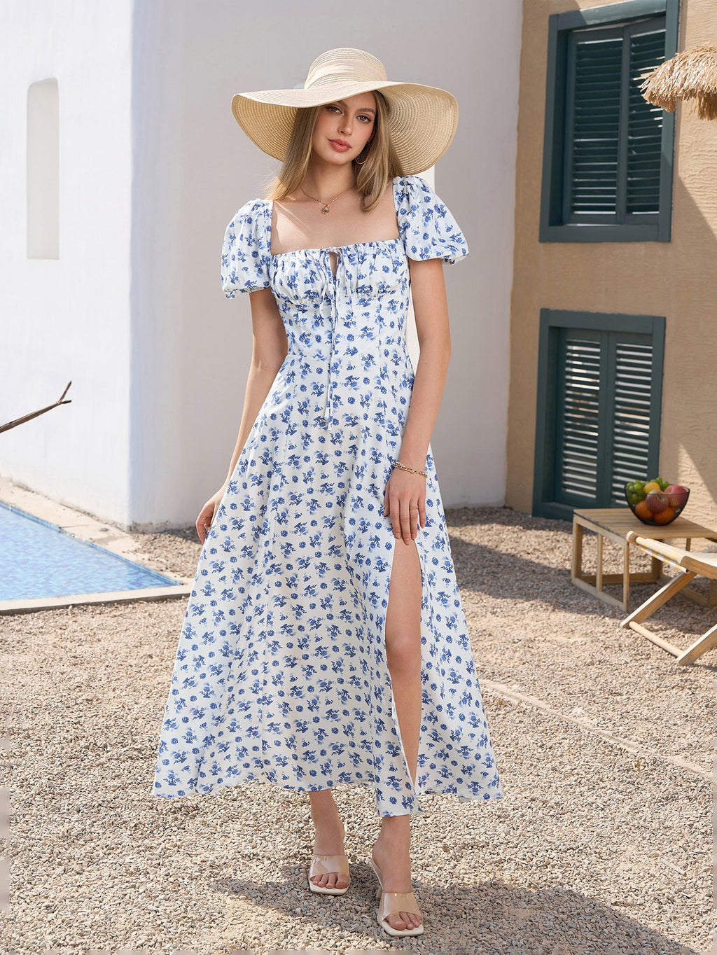 Full body shot of a woman in a floral print maxi dress and a straw hat