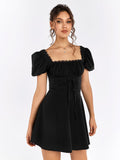 Woman in a black short puff sleeve square neck dress, showing the ruched bodice and corset lacing detail.