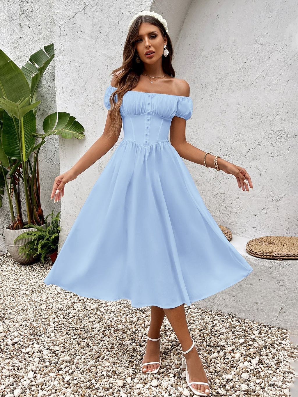 Woman wearing a light blue off-the-shoulder chiffon midi dress with button front detail.
