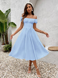 Woman wearing a light blue off-the-shoulder chiffon midi dress with button front detail.