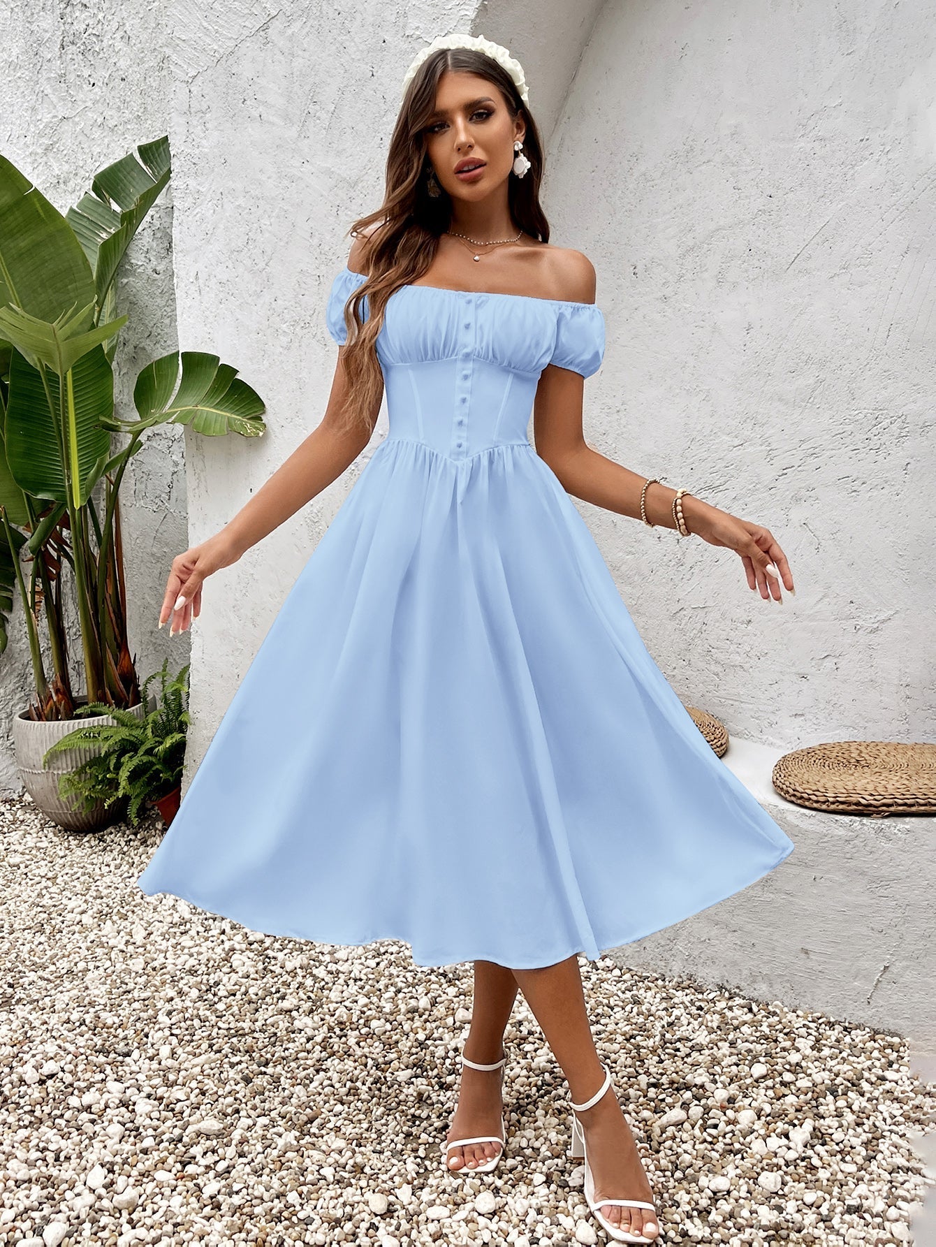 Woman wearing a light blue off-the-shoulder chiffon midi dress with button front detail.