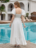 Rear view of a woman in a white puff sleeve maxi dress with a smocked waist by a pool.