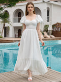 Full length view of a woman in a white puff sleeve maxi dress by a pool.