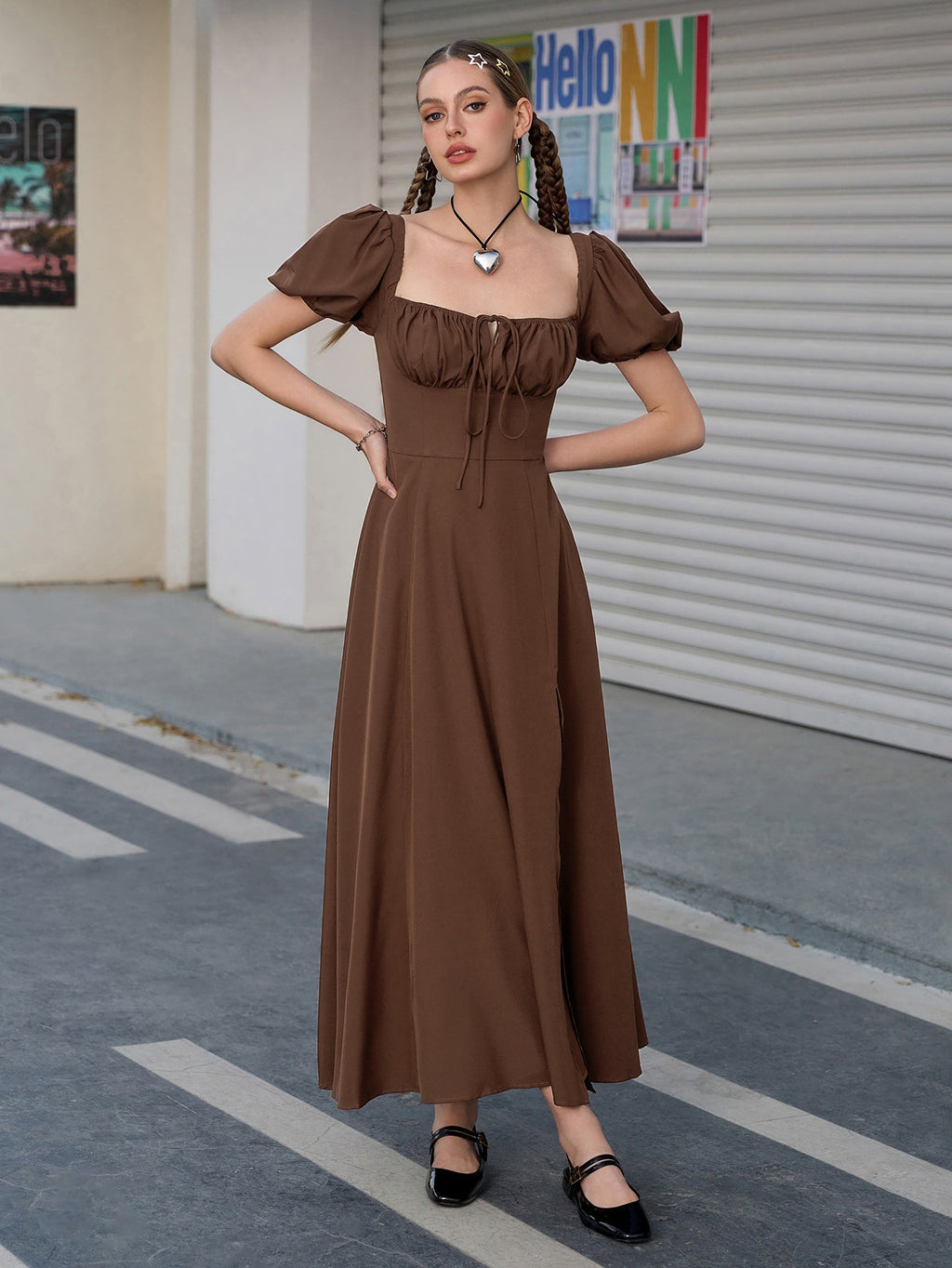Woman posing in a brown puff sleeve midi dress with a high slit