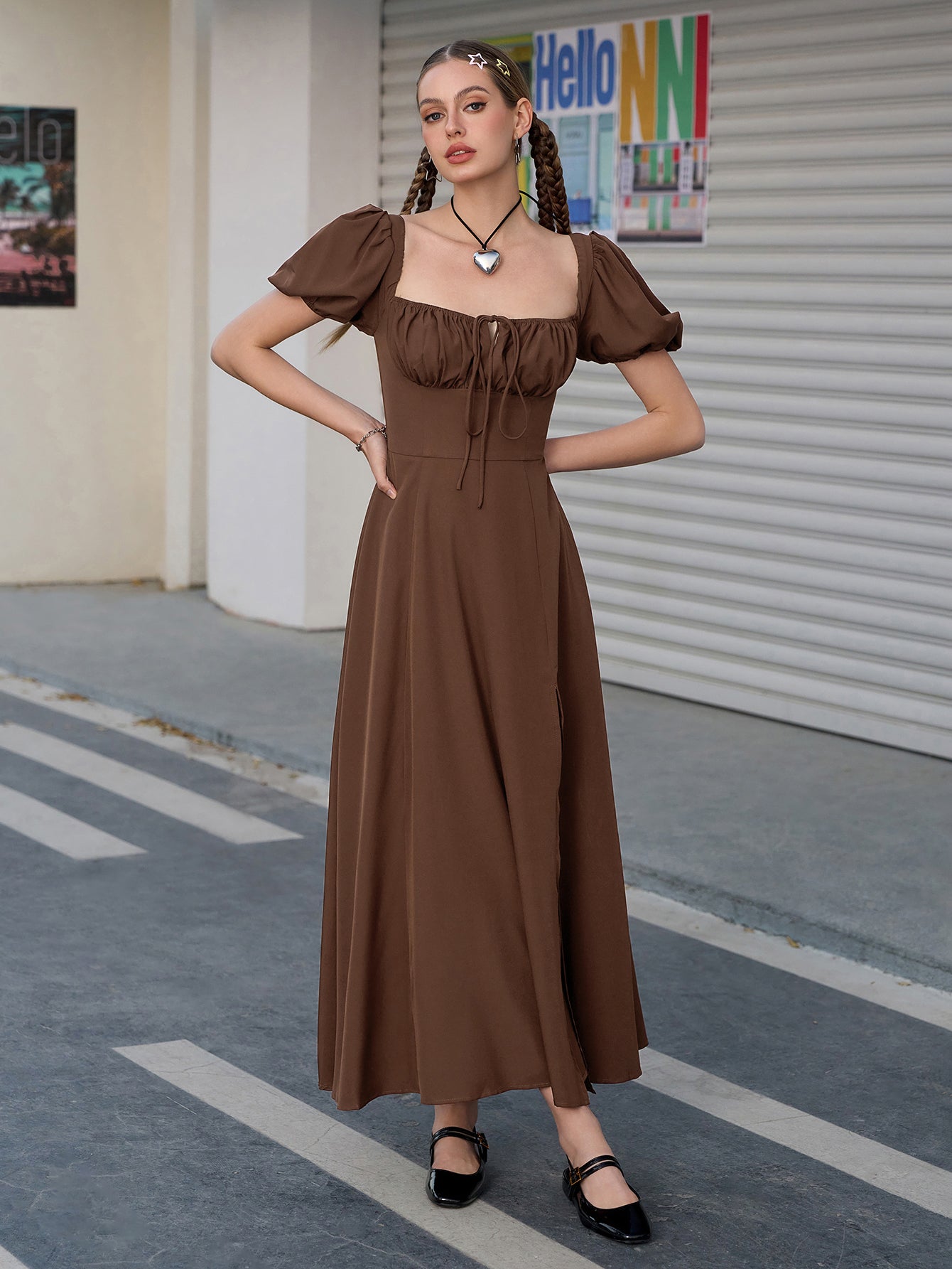 Woman posing in a brown puff sleeve midi dress with a high slit