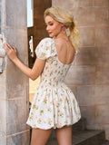 Back view of a woman in a cream floral print mini dress with puff sleeves.