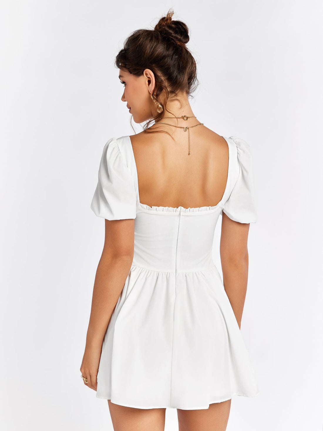 Woman wearing a white short dress with puff sleeves and a square neckline