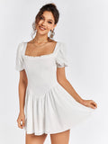 Woman wearing a white short dress with puff sleeves and a square neckline