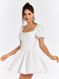 Woman twirling in a white short dress with puff sleeves and a square neckline