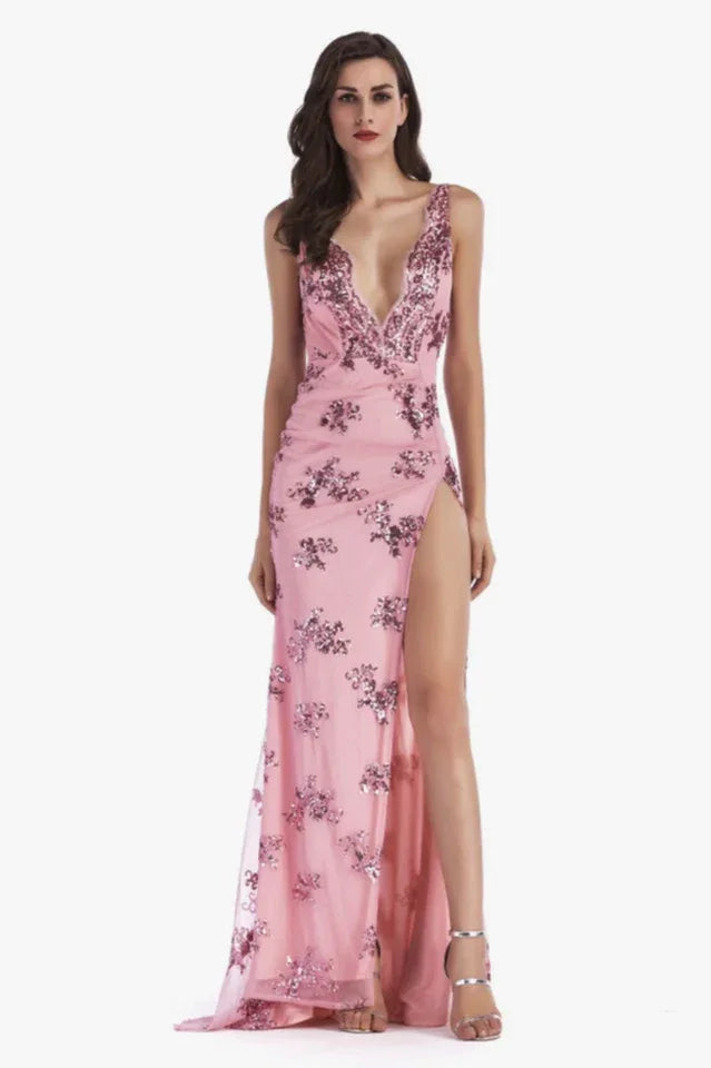 Woman in a pink sequined V-neck, sleeveless evening gown with a high leg slit and open back.