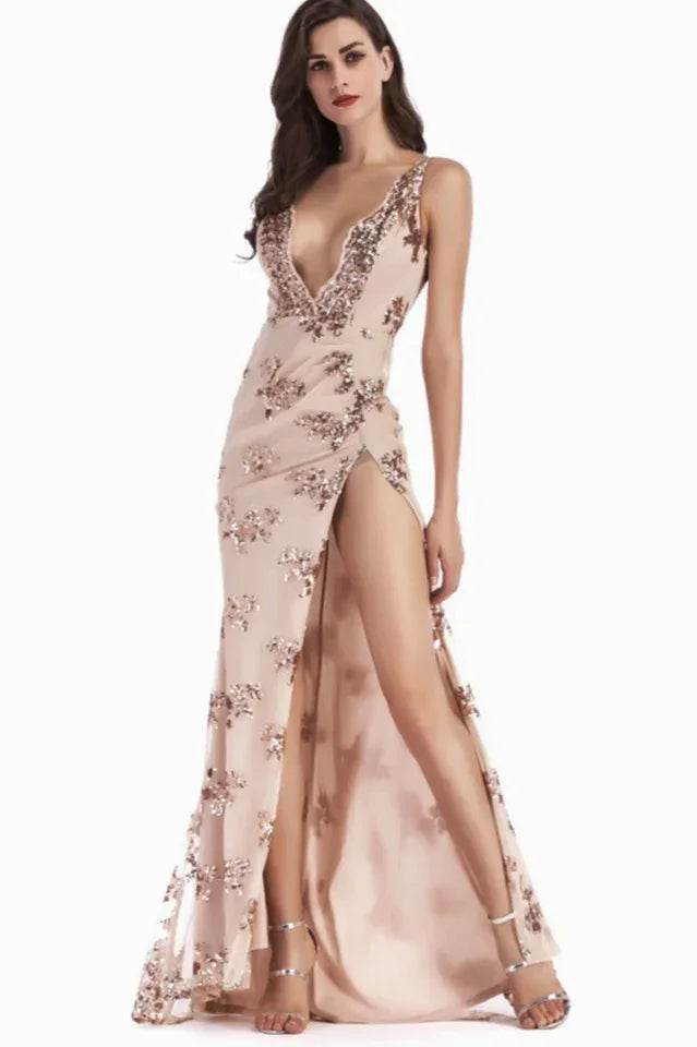 Woman in a blush sequined V-neck, sleeveless evening gown with a high leg slit and open back.