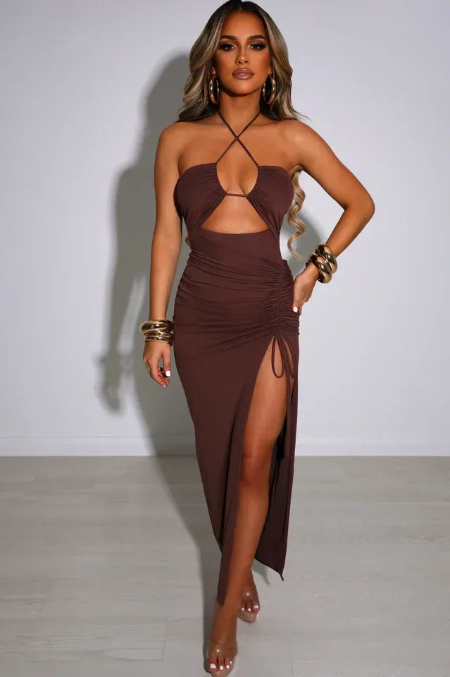 Front view of a woman in a brown ruched halter neck dress with a high slit.