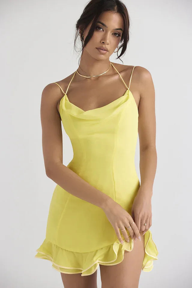 Woman wearing a bright yellow satin mini dress with a cowl neckline and ruffle hem. Main image