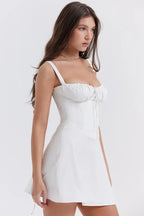 Side view of a woman in a white A-line mini dress with a sweetheart neckline and corset bodice.