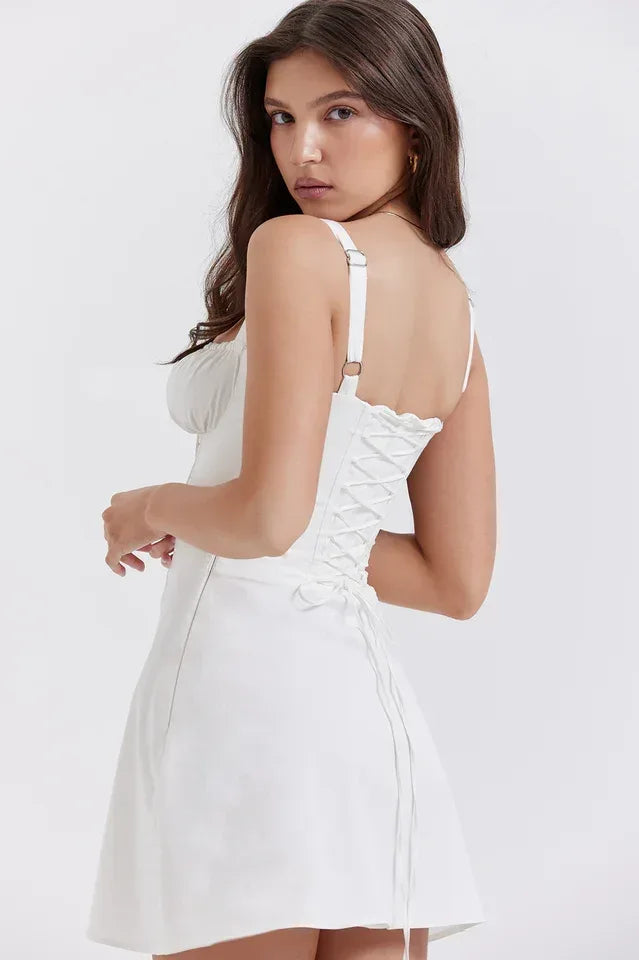 Back view of a white corset-style mini dress with a lace-up detail and adjustable shoulder straps.