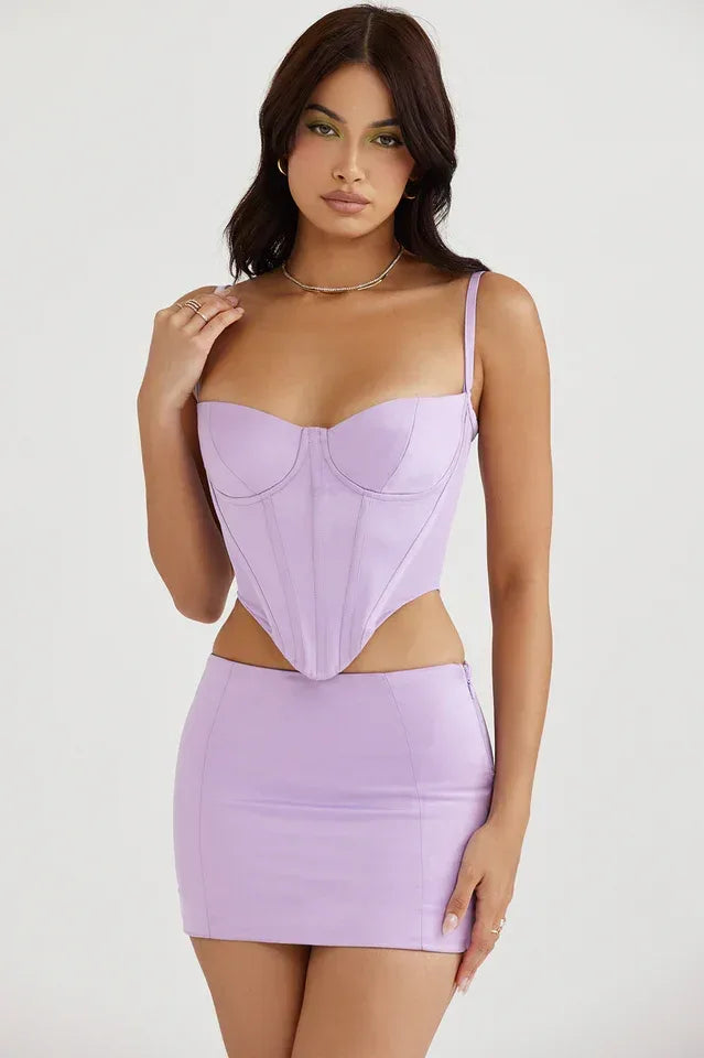 Front view of a woman in a lavender faux leather corset top paired with a matching mini skirt.