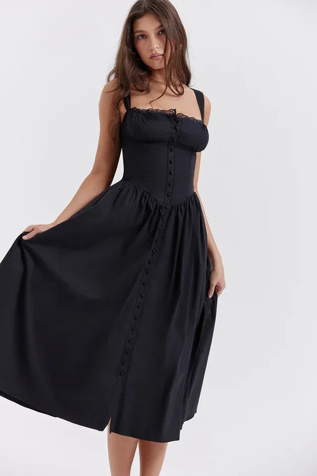 Woman holding the skirt of a black midi dress with a gathered waist