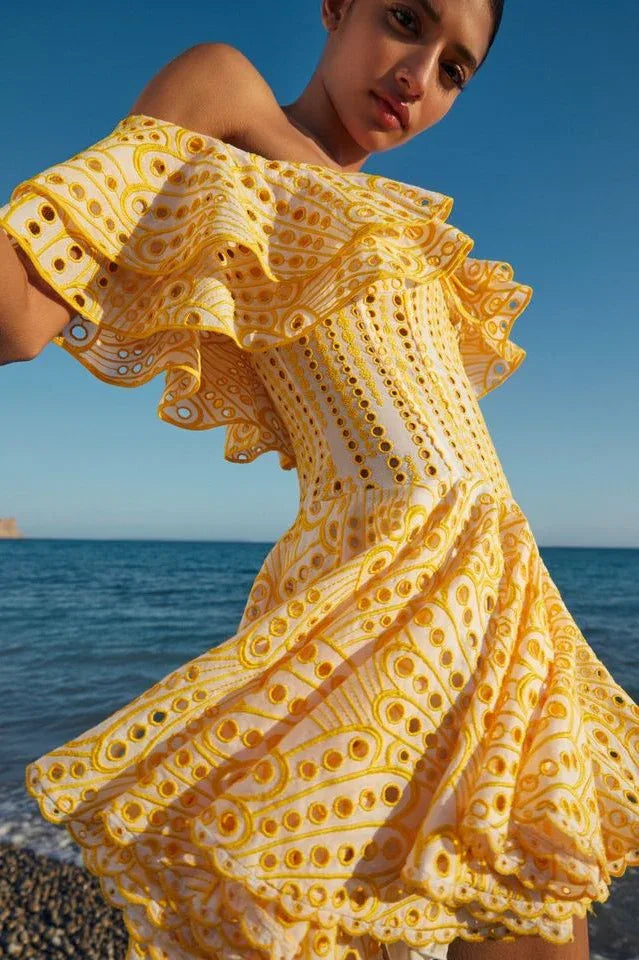 Close-up of the ruffled neckline of a yellow Bardot dress