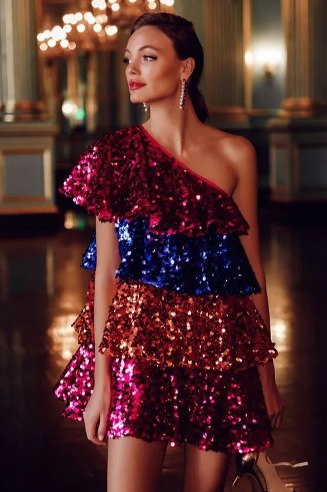 Woman wearing a multi-colored sequin one-shoulder mini dress with tiered ruffles.