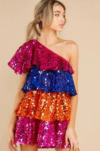 Front view of a woman showcasing a colorful sequin tiered dress.