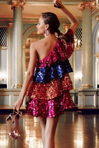 Back view of a woman in a dazzling sequin dress with a one-shoulder cut.