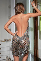 Back view of a woman in a silver sequin halter dress.