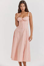 Close-up of a woman in a pink cotton poplin midi dress, focusing on the bodice and neckline details.