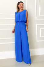 woman wearing a royal blue wide leg jumpsuit with a round neck and open back