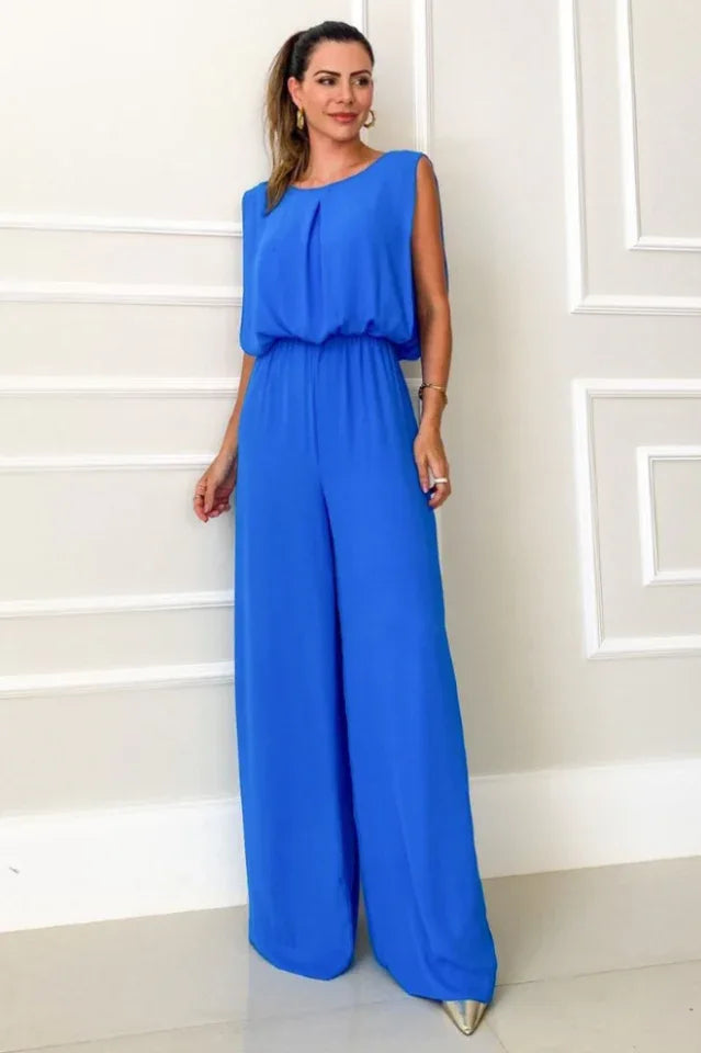 woman wearing a royal blue wide leg jumpsuit with a round neck and open back