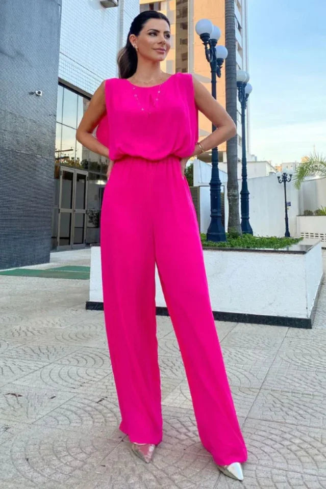 woman wearing a hot pink wide leg jumpsuit with a round neck and sleeveless design
