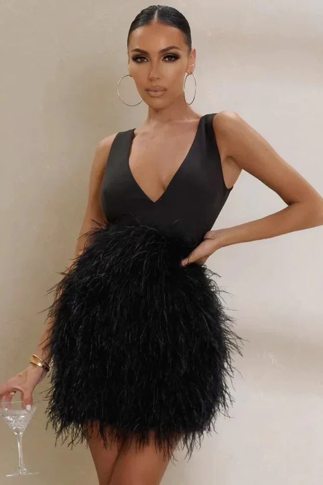 Woman wearing a black sleeveless mini dress with a plunging V-neckline and a full feather skirt. Main image