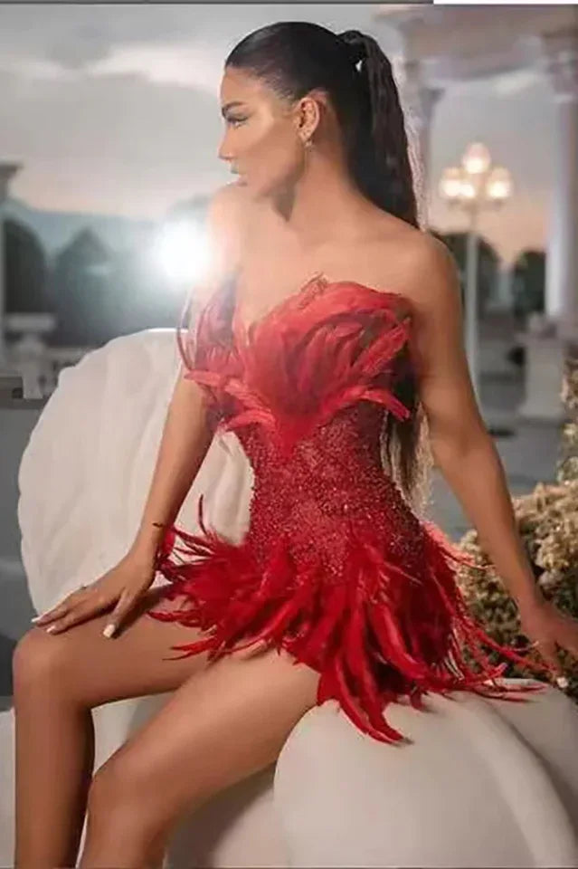 Woman sitting wearing a red sequin and feather strapless dress