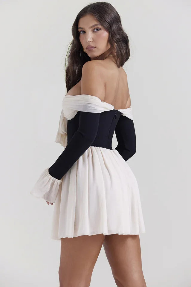 Rear view of a woman in a black and cream off-the-shoulder mini dress