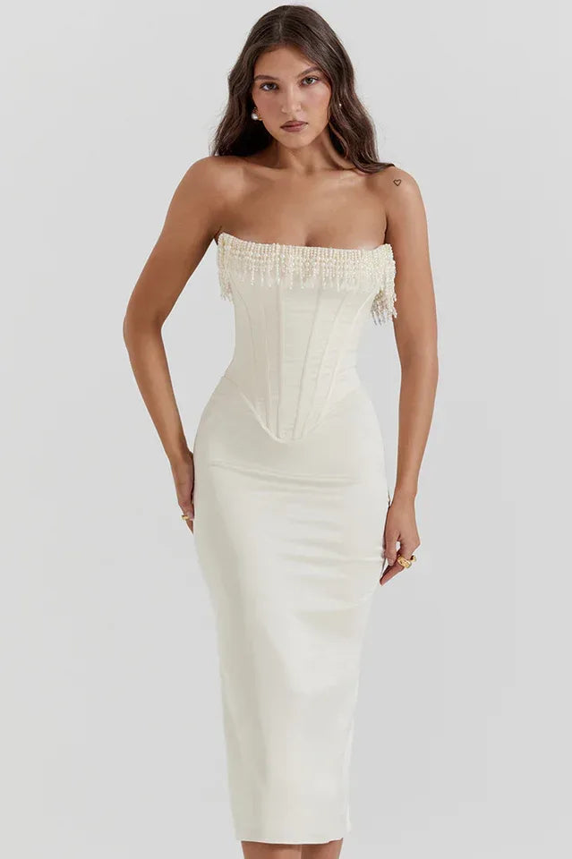 Model in a white satin strapless corset midi dress with intricate beaded embellishments along the neckline.