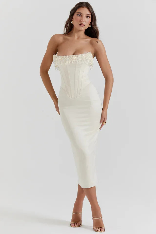 Woman wearing a white satin strapless corset midi dress with beaded trim. Main image