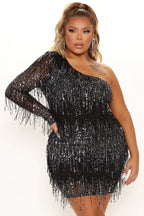 Woman wearing a black sequined one-shoulder mini dress with fringe detail
