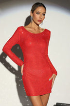Woman in a red rhinestone long-sleeve bodycon mini dress with a scoop neckline, posing with hands on hips.