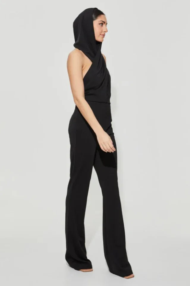 Side view of black jumpsuit with integrated hood and flared legs