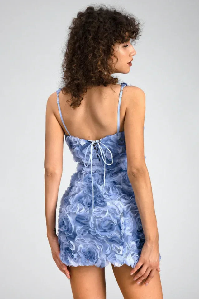 Model wearing a blue floral mini dress with 3D rose embellishments